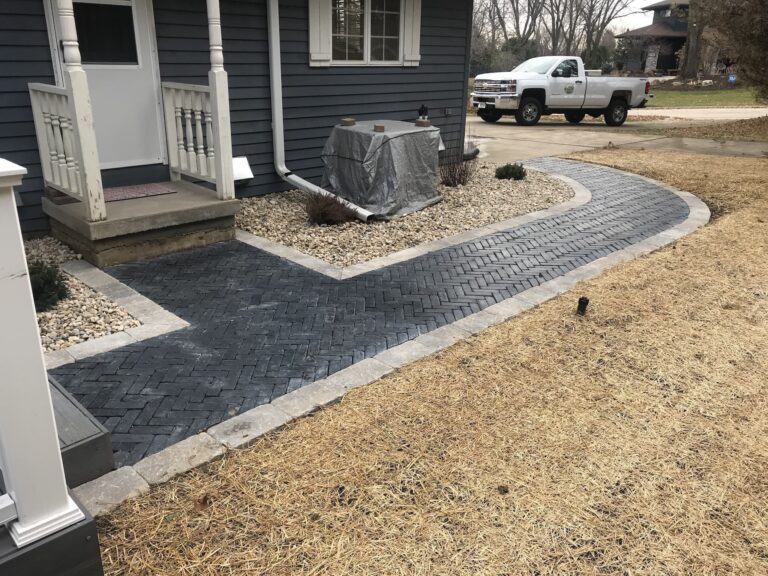 Curved paver walkway at residential home entrance.